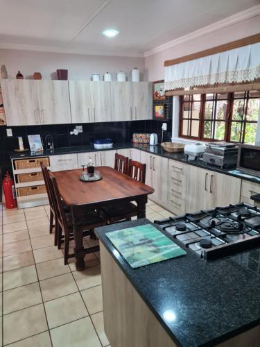 a large kitchen with a wooden table and a tableasteryasteryasteryasteryasteryastery at The Blue Swallow in Kaapsehoop