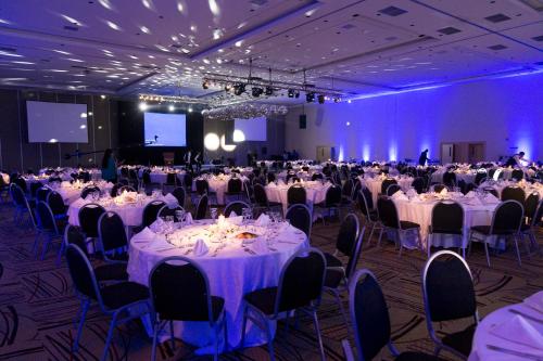 a room filled with tables and chairs with purple lighting at Gala Hotel y Convenciones in Resistencia
