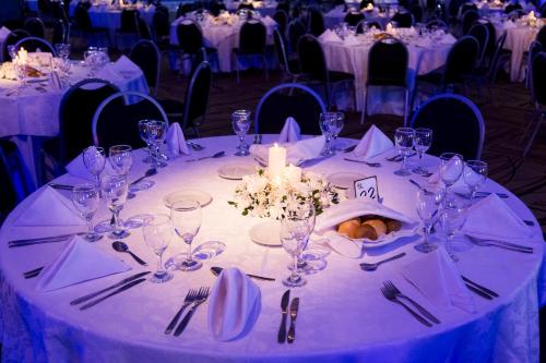 a table with glasses and a candle on it at Gala Hotel y Convenciones in Resistencia