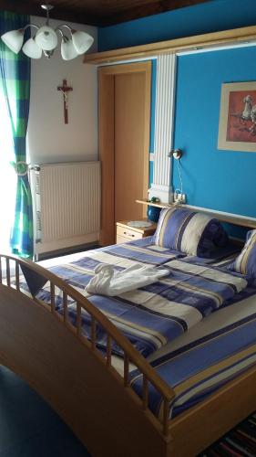 1 dormitorio con 1 cama con una cruz en la pared en Urlaub am Bauernhof Unger, en Grabersdorf