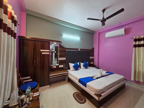 a bedroom with a bed with purple walls at RESORT SAIKAT SARANYA in Mandarmoni