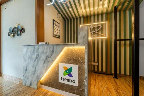 eine Lobby mit einem Tiero-Schild auf einem Marmortresen in der Unterkunft Treebo MR Motel, 10 Mins To Airport in Mattanūr