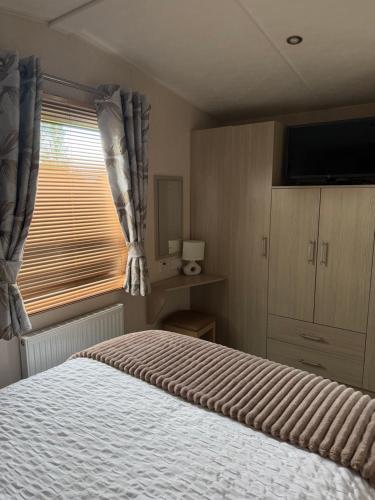 a bedroom with a large bed and a window at 20 The Green, Lilliardsedge in Jedburgh