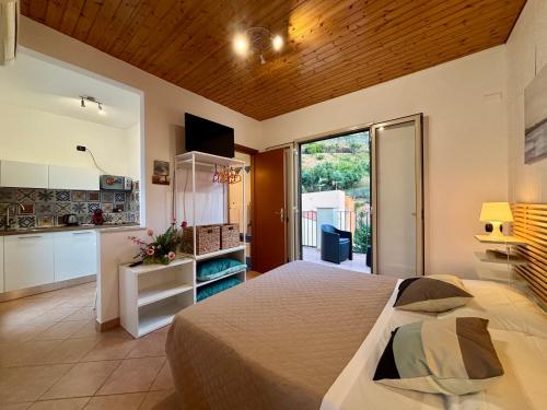 a bedroom with a large bed and a kitchen at La Casa Sulla Scogliera in Cefalù