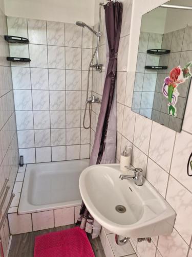 a bathroom with a sink and a bath tub at Apartment 4 nähe Elmshorn Barmstedt in Bokholt-Hanredder
