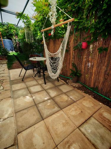 a hammock hanging from a fence in a backyard at Libelloula's apartment google it in Lygia