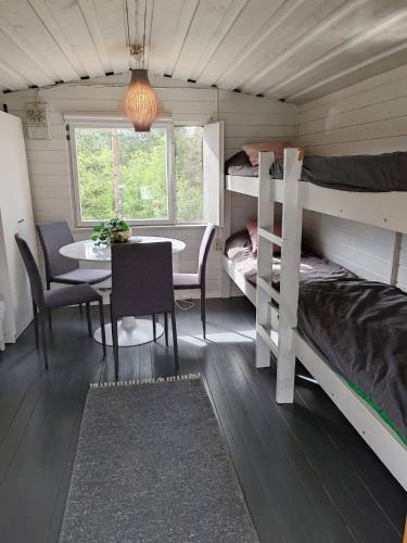 a room with two bunk beds and a table and a dining room at Lemmenjoen Lumo - Nature Experience & Accommodation in Lemmenjoki