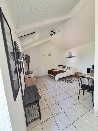 a bedroom with a bed and a table and chairs at Studio 09 in Sulniac