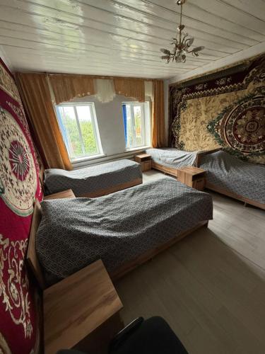 ein Schlafzimmer mit zwei Betten und zwei Fenstern in der Unterkunft Arnas in Barskoon