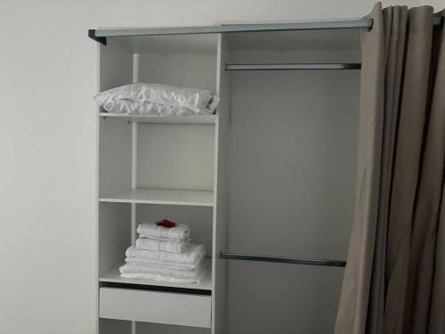 a white refrigerator with some towels in it at Appartement rénové, RDC, proche commodités in Armentières