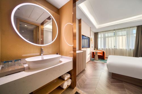 a bathroom with a sink and a mirror at Ibis Styles Liyang Shanghecheng in Liyang