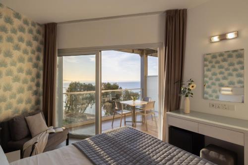 a bedroom with a bed and a view of the ocean at Harmony Bay Hotel in Limassol