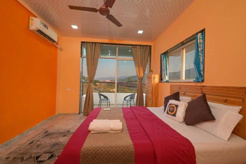 a bedroom with a bed with orange walls and a window at ll VIBE WITH US II BIG DADDY VILLA II 6BHK II AC II PRIVATE POOL II in Lonavala