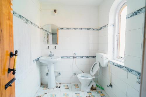 a bathroom with a toilet and a sink at Pahalgam Resort and Cottages in Pahalgām