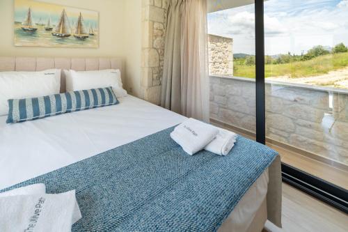 a bedroom with a bed and a large window at The Olive Path in Kalandra