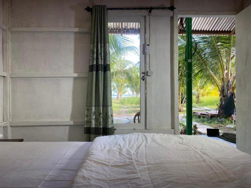 a bedroom with a bed and a large window at The Green Pearl Paradise in Biluhu