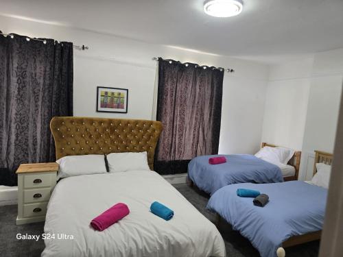 a room with two beds with red and blue pillows at J & T property in Great Coates