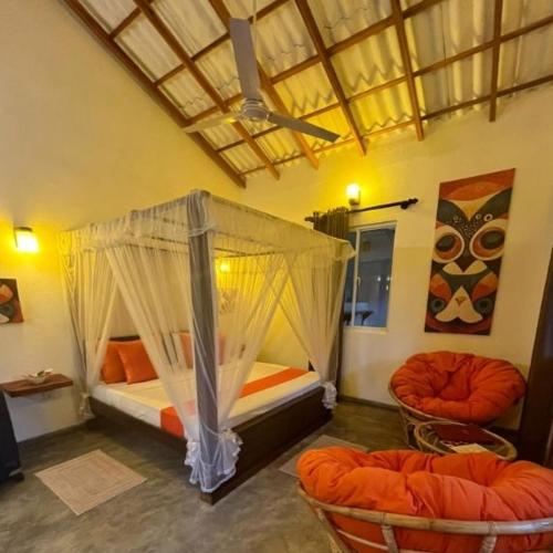 a bedroom with two beds and two chairs at La Perla Bentota in Bentota