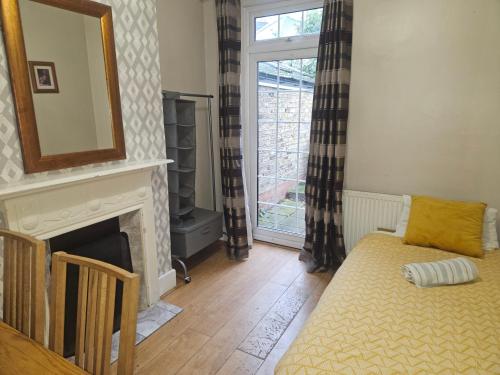 a living room with a fireplace and a mirror at Nice 3 Bedroom House Ealing in London