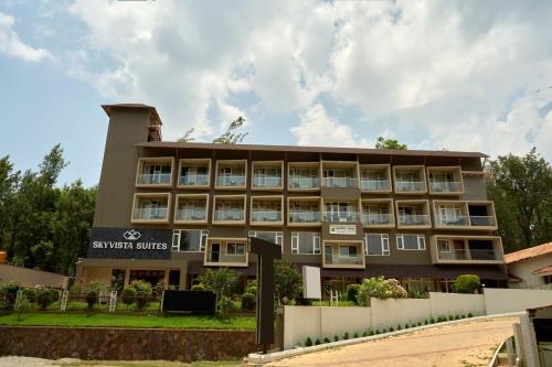 a building with a sign for a hotel at Treebo Sky Vista Suites with Hill View in Chikmagalūr