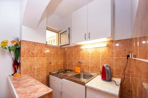 a small kitchen with a sink and a window at Jadran Apartments in Rafailovici