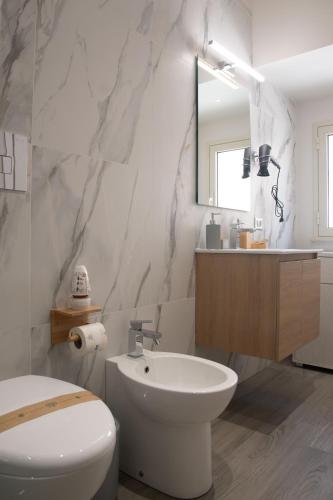 a bathroom with a white toilet and a sink at Il Vicolo al Centro in Raffadali