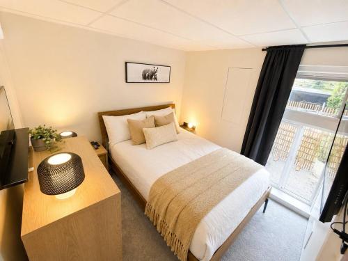a bedroom with a bed and a large window at Modern North Van Escape with 2BR BBQ Workspace in North Vancouver