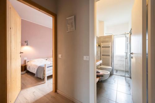 a bedroom with a bed and a bathroom with a toilet at B&B Benvenuto in Venegono Superiore