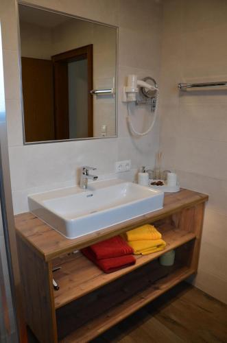 a bathroom with a sink and a mirror and towels at Gästehaus Wildauer in Schlitters