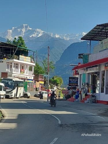 eine Person, die mit einem Motorrad eine Stadtstraße entlangfährt in der Unterkunft Devadidev Retreat in Gupta Kāshi