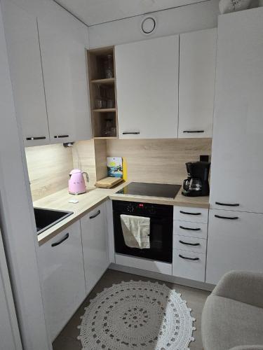 a kitchen with white cabinets and a pink appliance at LinnankadunHelmi in Savonlinna