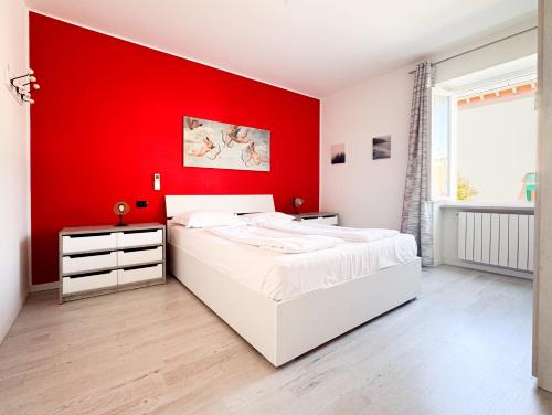 a bedroom with a red wall and two beds at Apartment Verdi BARDOLINO in Bardolino