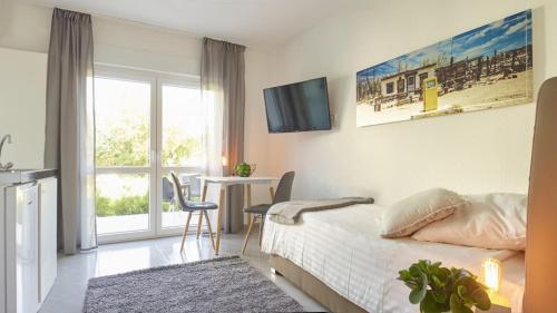 a bedroom with a bed and a table and a television at City Hotel ApartW3 - kostenlos parken in Bad Oeynhausen