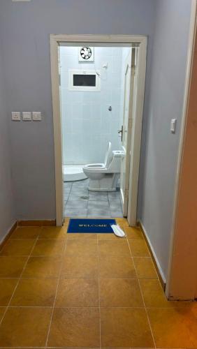 a bathroom with a toilet and a tile floor at شالية الرايس in Rayyis