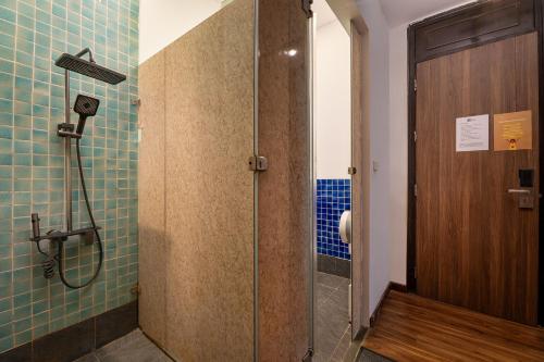 a shower with a glass door in a bathroom at Drift Backpackers Hostel in Hanoi