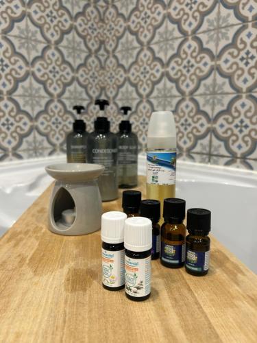 a group of bottles of essential oils on a wooden table at Suite Une Bulle d Evidence avec baignoire spa in Saumur