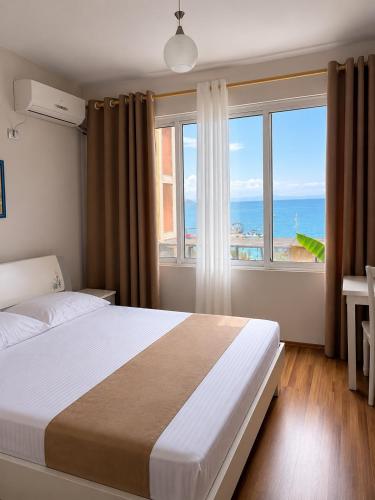 a bedroom with a bed with a view of the ocean at British Hotel in Himare