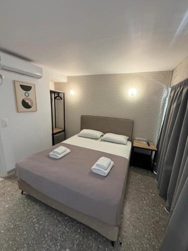 a bedroom with a bed with two towels on it at athensdot in Athens