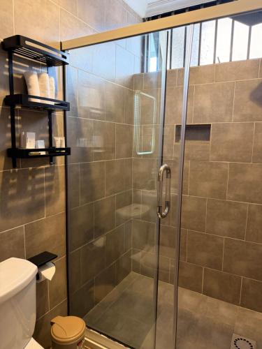 a shower with a glass door in a bathroom at Elite Apartments Masaka in Kigali