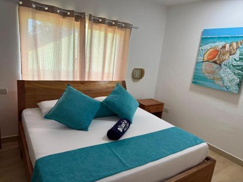 a bed with blue pillows in a bedroom at Blissful hill top Apartment in Praslin