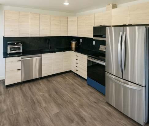 a kitchen with a stainless steel refrigerator and cabinets at Mountain Views - Peaceful Retreat - 1BR suite in Sooke
