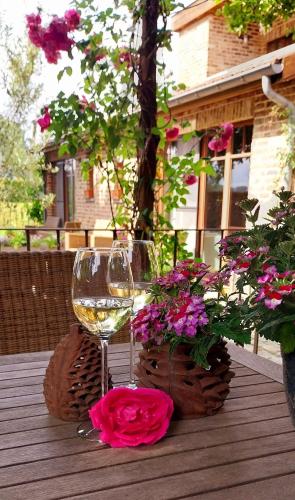 a glass of wine and flowers on a wooden table at B&B Het Hof van Petronilla in Gooik
