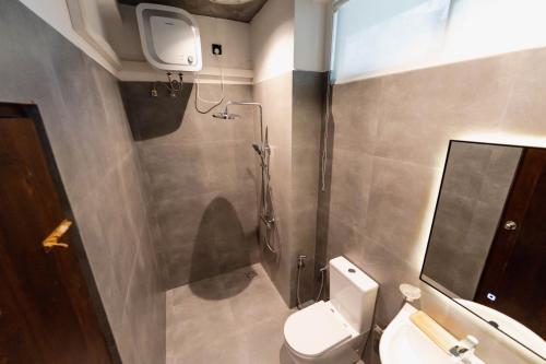 a bathroom with a toilet and a sink and a mirror at The Embrace Luxury Villa - Hiriketiya in Dickwella