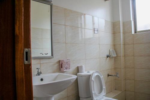 a bathroom with a toilet and a sink at Hidden Gems Homes Modern 2BR Near JKIA, Athi River in Athi River