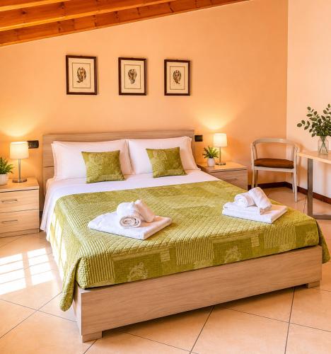 a bedroom with a large bed with towels on it at Residenza La Torre Pizzighettone in Pizzighettone