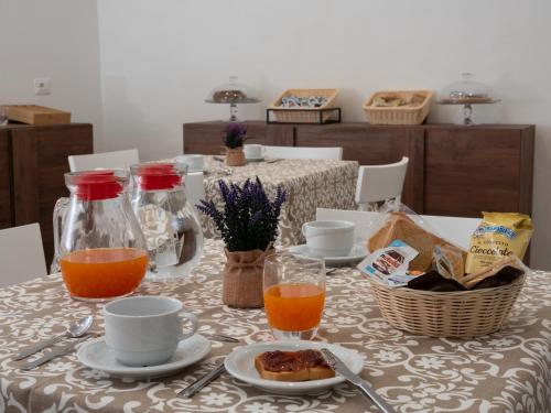a table with a plate of food and two glasses of orange juice at B&B La Via dei Mulini in Corigliano Calabro
