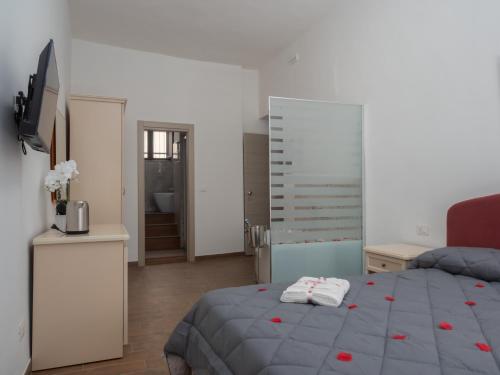 a bedroom with a bed with red roses on it at B&B La Via dei Mulini in Corigliano Calabro