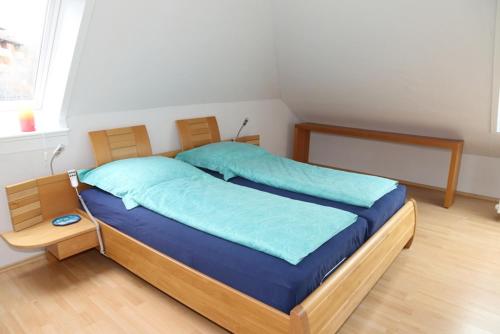 Bett mit blauer Bettwäsche in einem Zimmer in der Unterkunft Ferienwohnung Max-und-Moritz in Flensburg