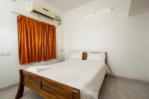 a bedroom with a bed and a window with a heater at FM Villa Auroville in Pondicherry