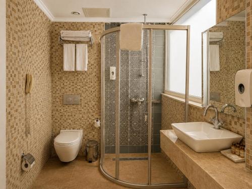a bathroom with a shower and a toilet and a sink at Trend Park Hotel in Antalya